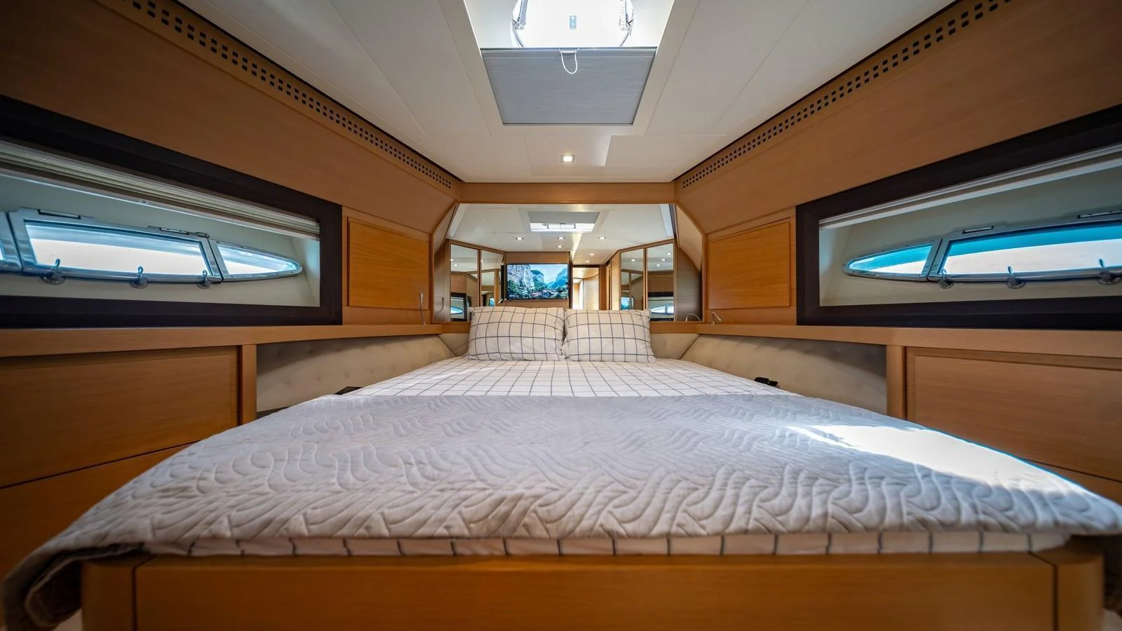 A luxurious stateroom with a large bed and ample natural light from side windows. aboard FREEDOM 2 Yacht for Sale