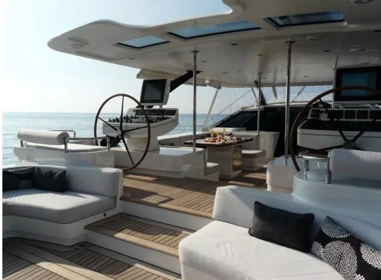 The aft deck features luxurious seating and dining areas under a sleek canopy. aboard VALQUEST Yacht for Sale