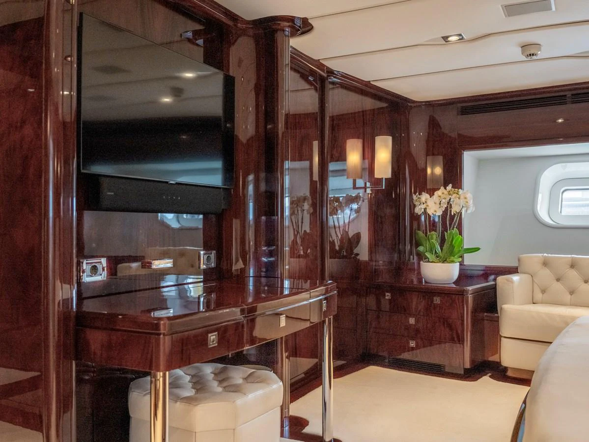The stateroom features luxurious wood paneling, a flat-screen TV, and elegant lighting. aboard VALQUEST Yacht for Sale