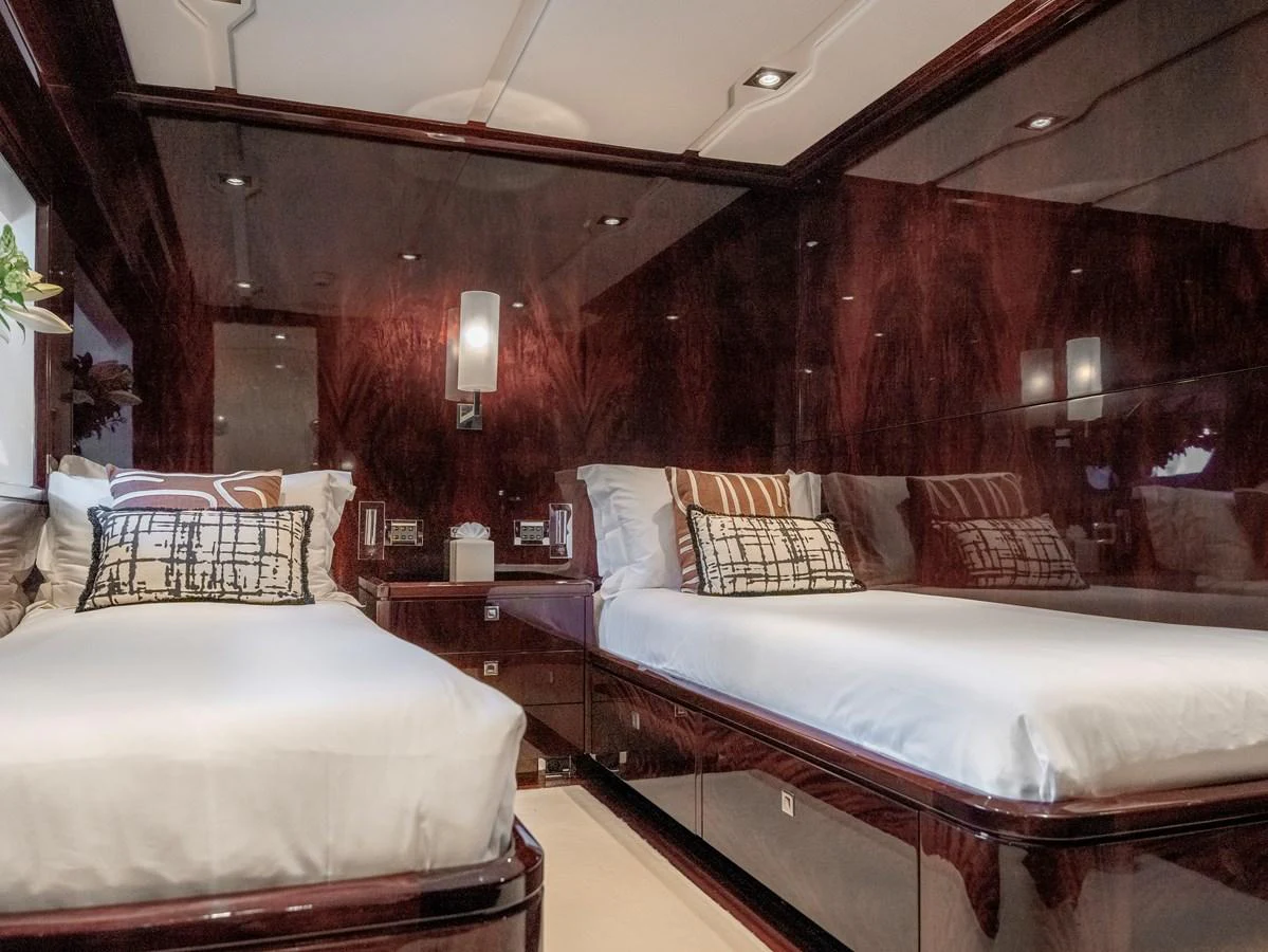 The guest stateroom features twin beds with luxurious bedding and rich wood paneling. aboard VALQUEST Yacht for Sale
