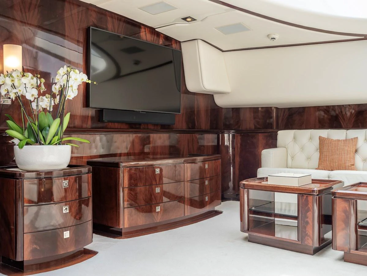 The yacht's interior features elegant wood furnishings and a comfortable seating area with a large television. aboard VALQUEST Yacht for Sale