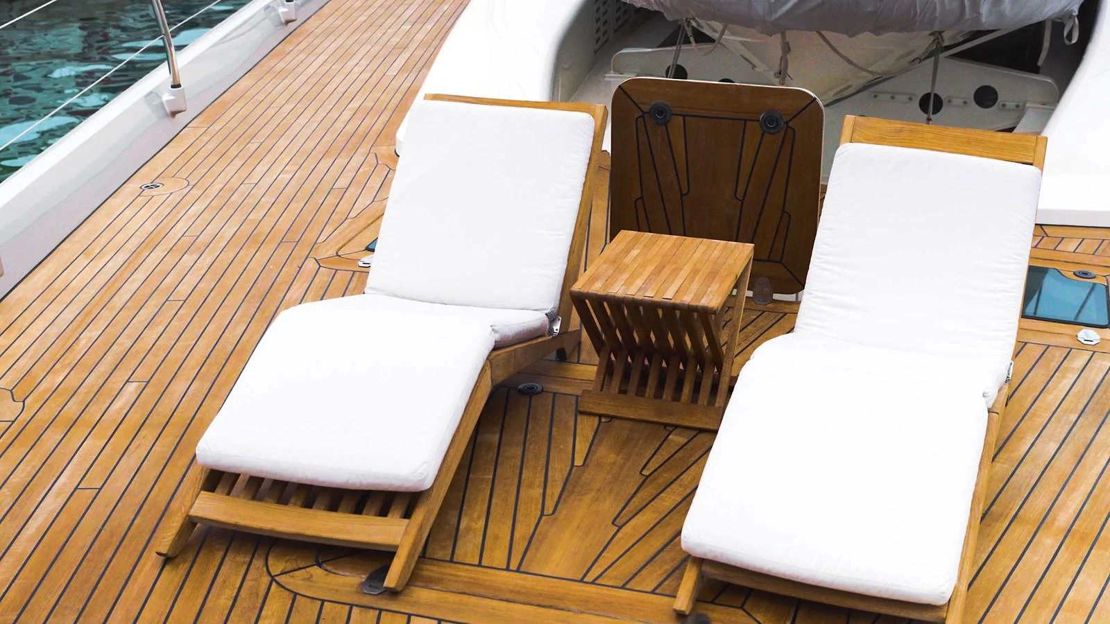 The sundeck features comfortable wooden loungers with white cushions, perfect for relaxation. aboard VALQUEST Yacht for Sale