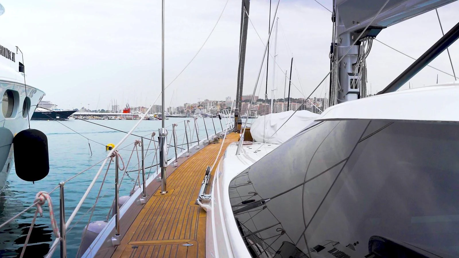 The yacht is docked at a marina, showcasing its sleek deck and modern design. aboard VALQUEST Yacht for Sale