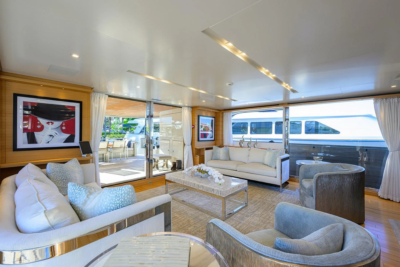 The salon features luxurious seating with ample natural light and elegant decor. aboard CHRISTINA Yacht for Sale