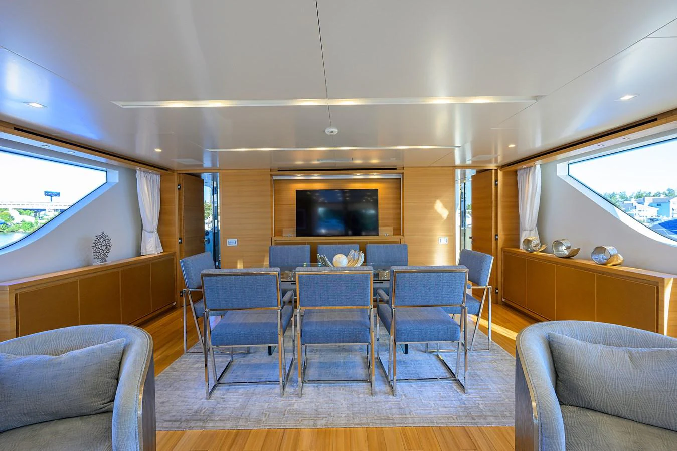The salon features a modern dining area with a large TV and ample seating. aboard CHRISTINA Yacht for Sale
