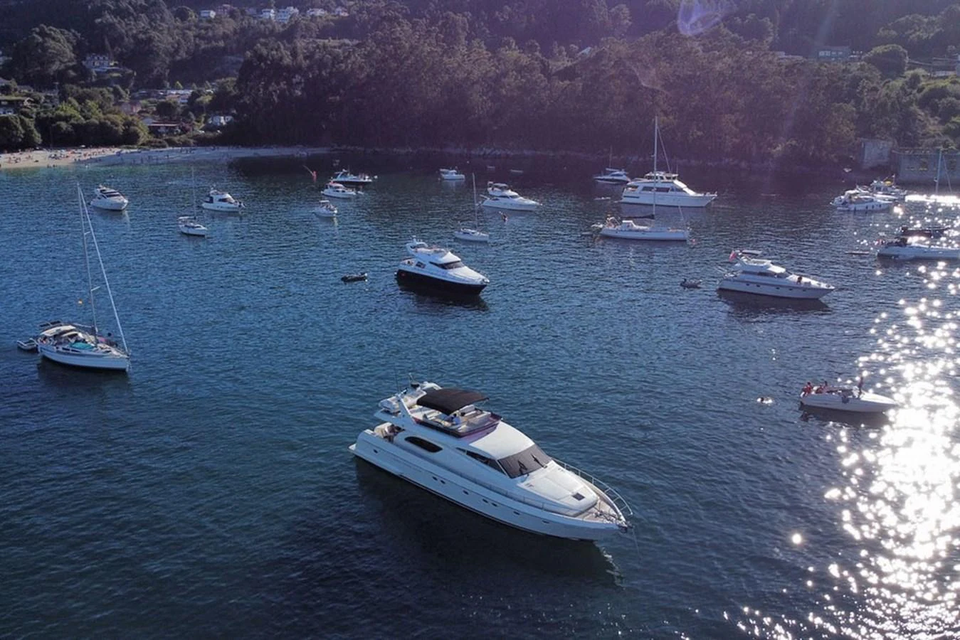 A sleek yacht cruises in a serene bay surrounded by other boats. aboard FERRETTI 70 Yacht for Sale