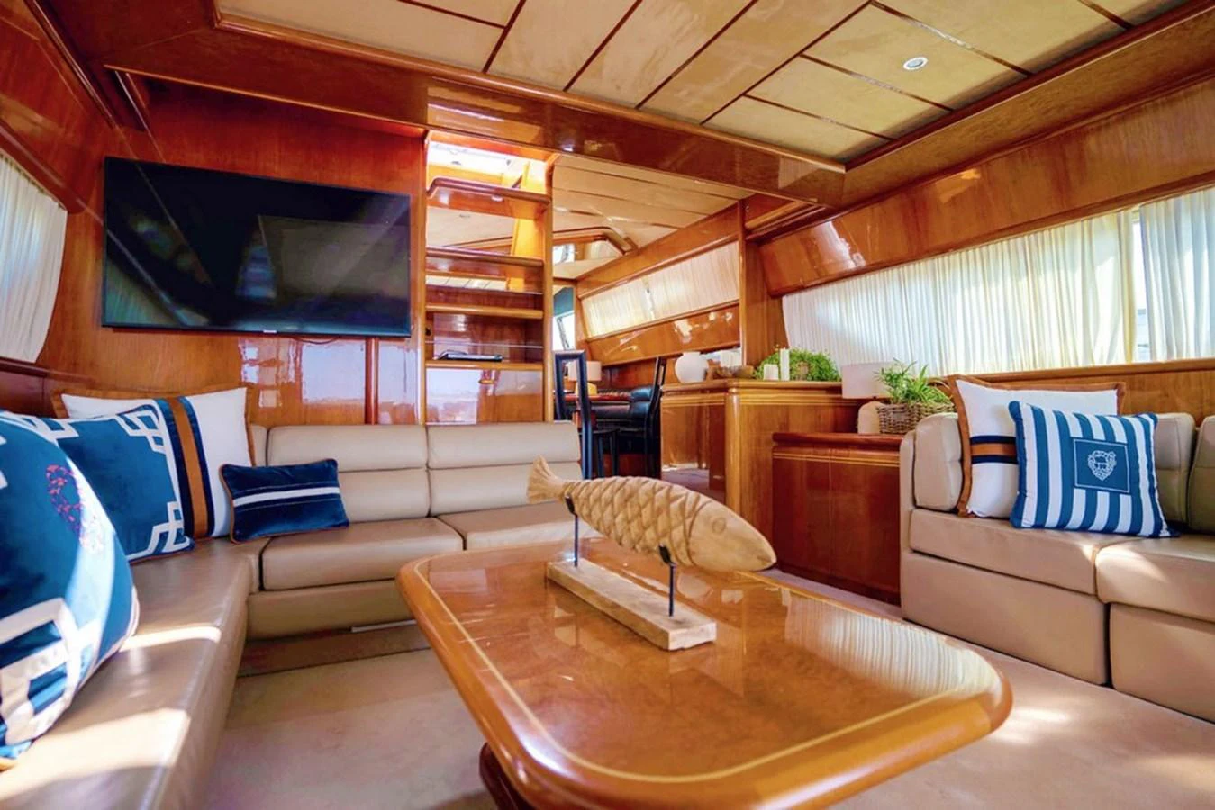 The yacht's salon features comfortable seating, a wooden coffee table, and a mounted television. aboard FERRETTI 70 Yacht for Sale