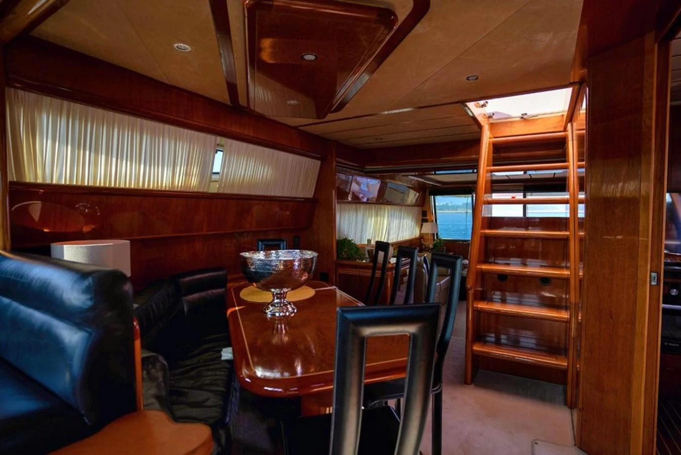 The yacht's salon features elegant wood finishes, comfortable seating, and a dining area with ample natural light. aboard FERRETTI 70 Yacht for Sale