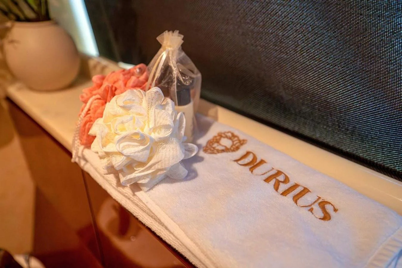 A close-up of luxurious toiletries and a branded towel on a yacht. aboard FERRETTI 70 Yacht for Sale