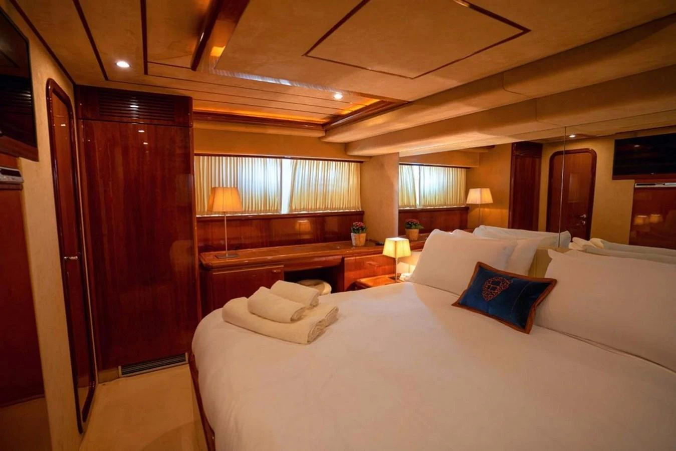 The stateroom features a luxurious bed with plush linens and warm ambient lighting. aboard FERRETTI 70 Yacht for Sale