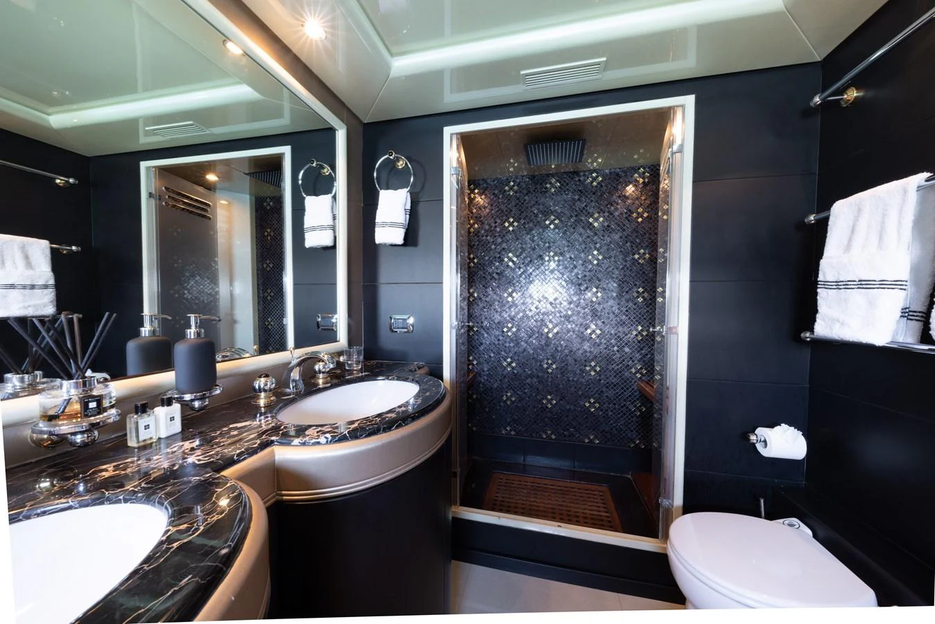 A luxurious yacht bathroom featuring a double sink vanity and a spacious shower with elegant tile work. aboard LAUREN V Yacht for Sale