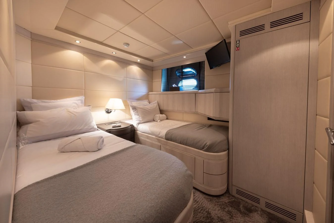 A cozy guest cabin featuring twin beds with plush bedding and soft lighting. aboard LAUREN V Yacht for Sale