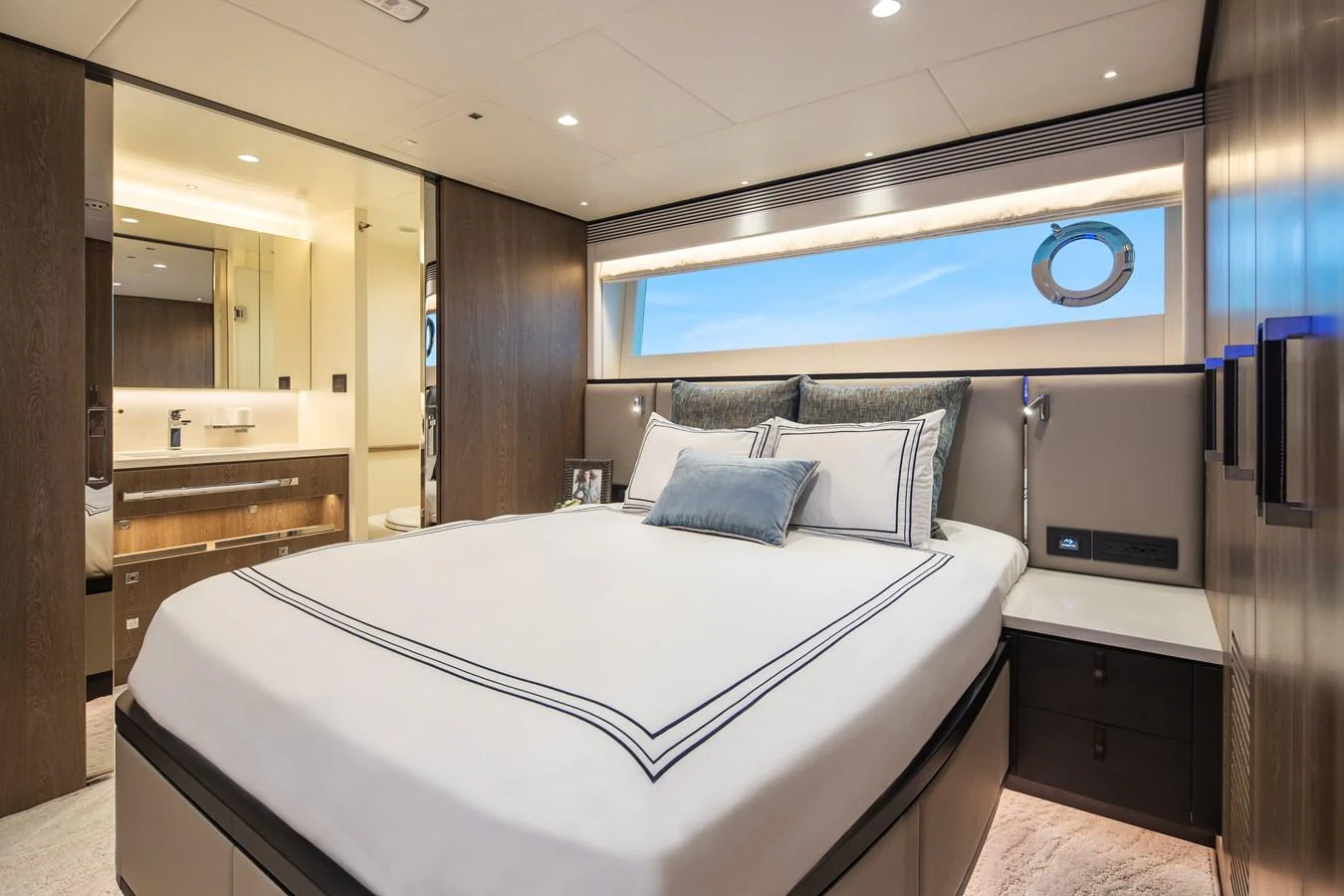 The stateroom features a luxurious bed with elegant linens and a modern ensuite bathroom. aboard HORIZON FD90 Yacht for Sale