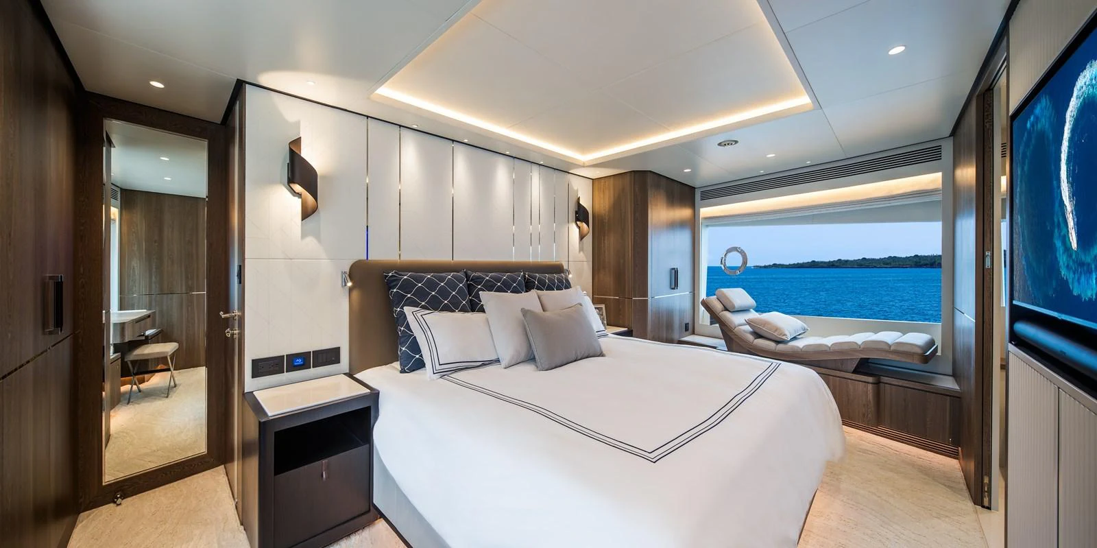 The master stateroom features a luxurious bed, modern decor, and a stunning view of the sea through large windows. aboard HORIZON FD90 Yacht for Sale