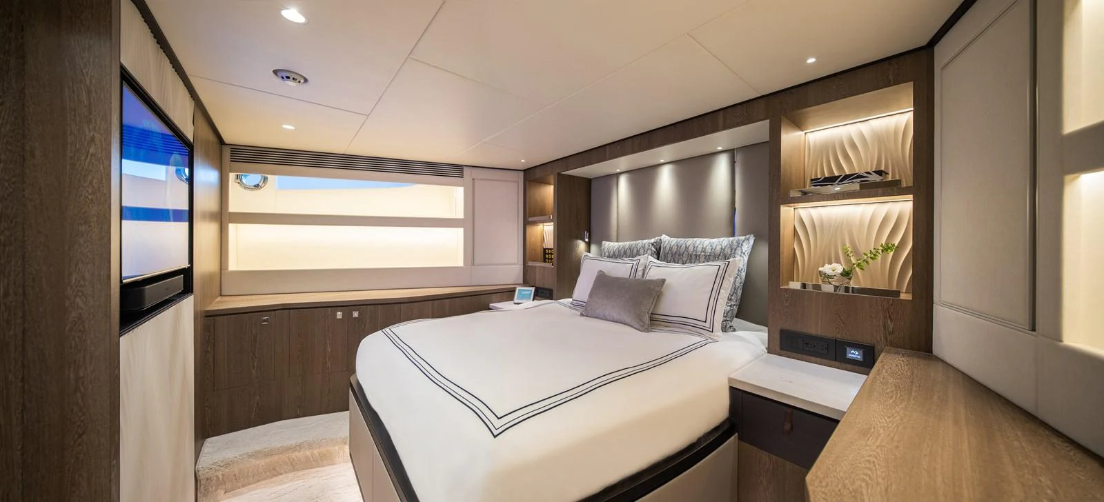 The master stateroom features a luxurious bed with elegant bedding and modern wood finishes. aboard HORIZON FD90 Yacht for Sale