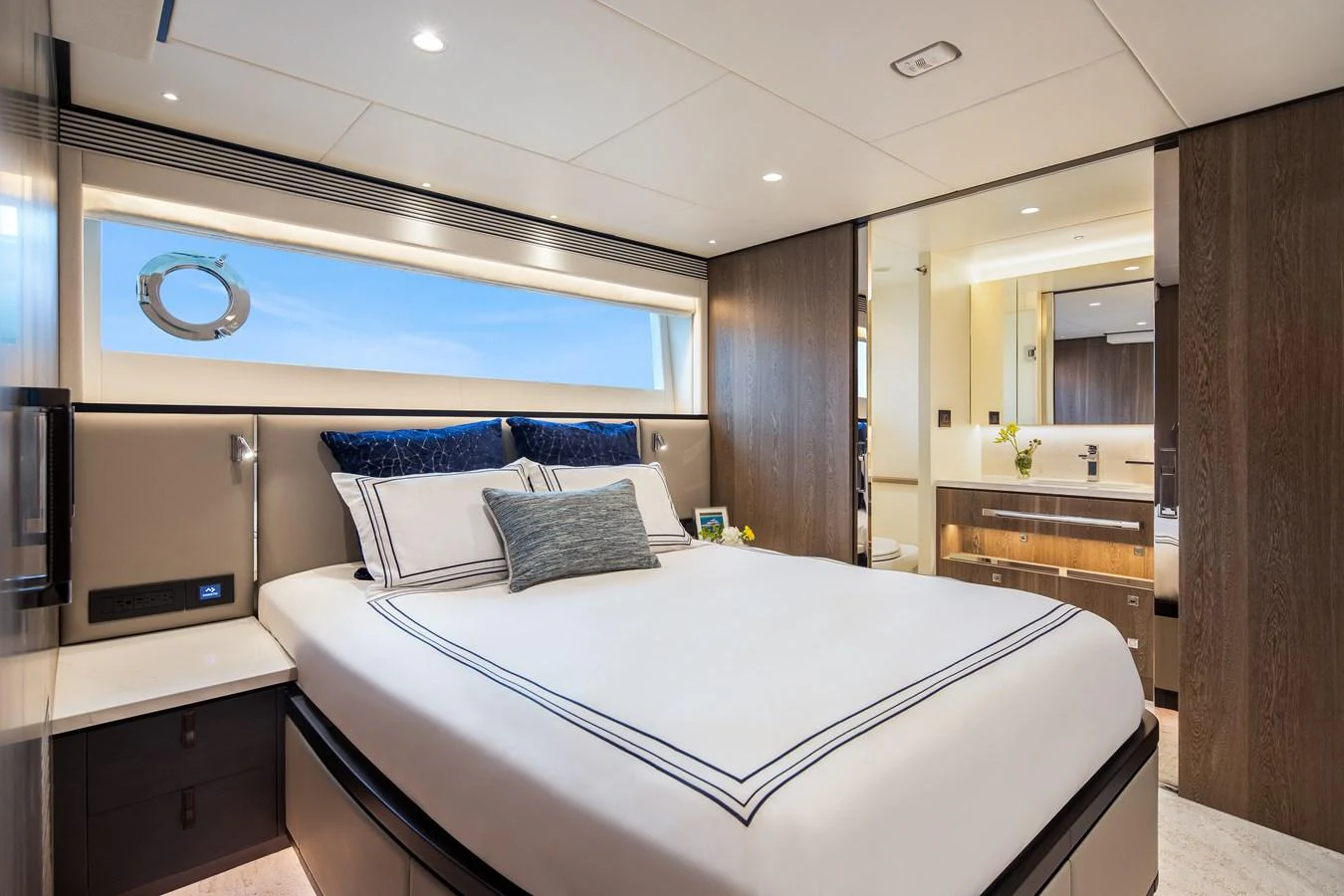 The stateroom features a luxurious bed with elegant linens and a view of the sea through a sleek window. aboard HORIZON FD90 Yacht for Sale