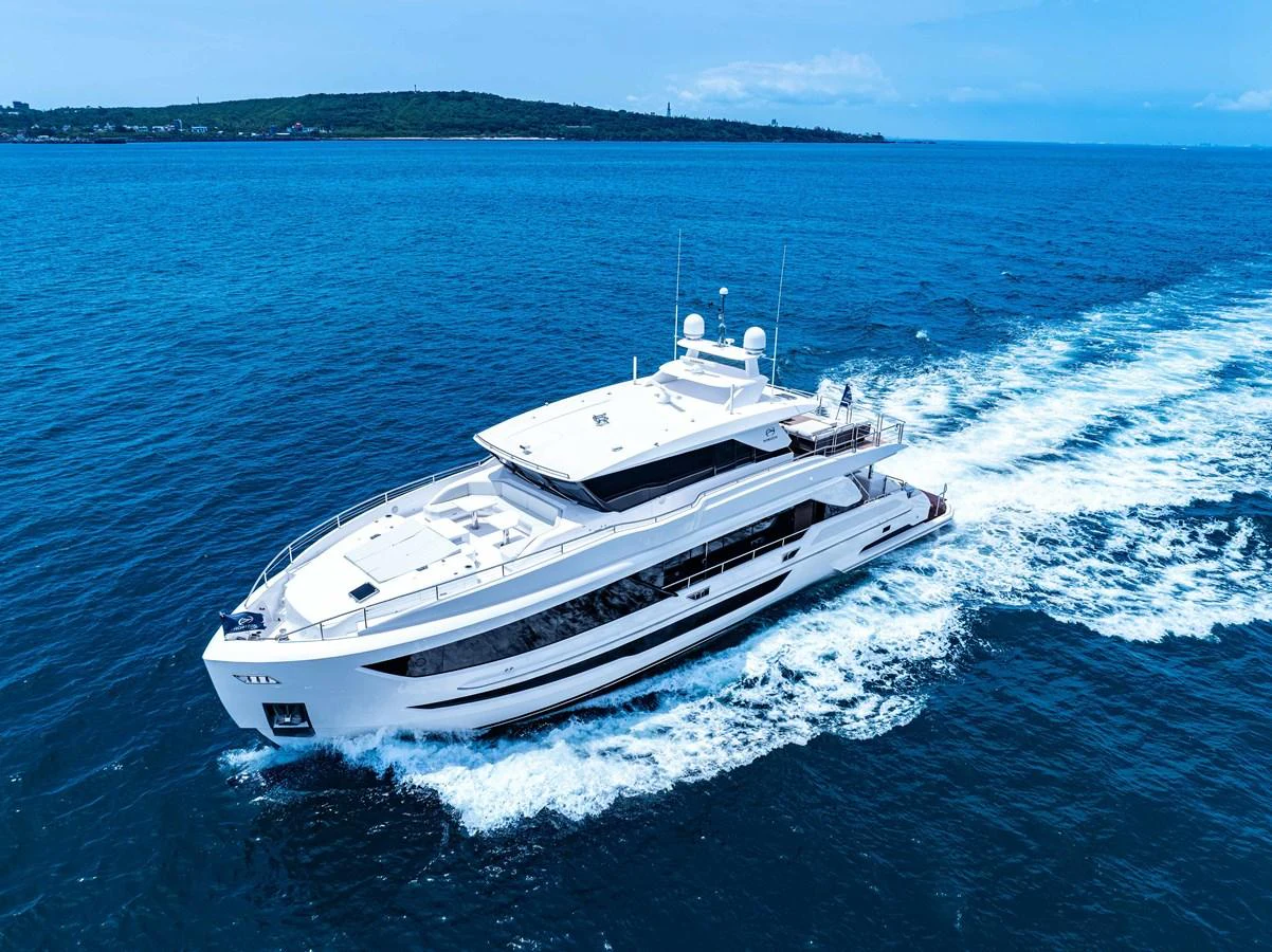 A sleek, modern yacht cruises through clear blue waters on a sunny day. aboard HORIZON FD90 Yacht for Sale