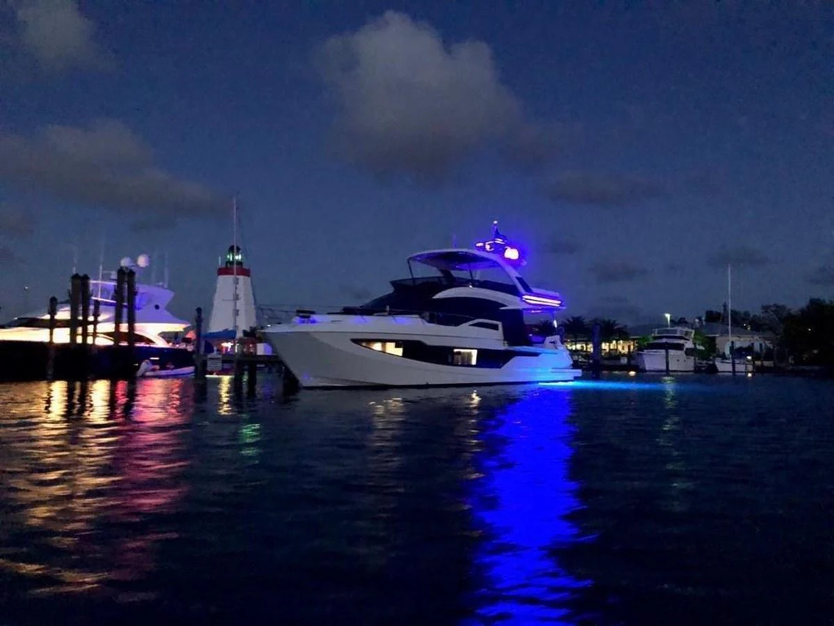 A striking yacht is illuminated against the night sky, creating a captivating scene on the water. aboard GODSPEED Yacht for Sale