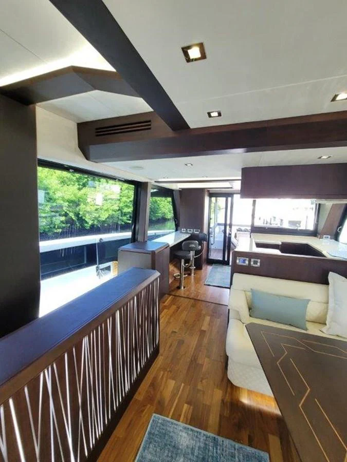 The yacht's interior features a modern design with a spacious seating area and large windows offering scenic views. aboard GODSPEED Yacht for Sale