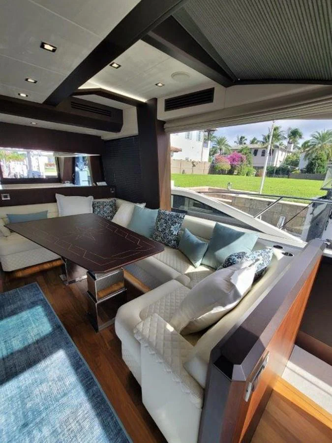 The yacht's salon features a comfortable seating area with large windows offering scenic views. aboard GODSPEED Yacht for Sale