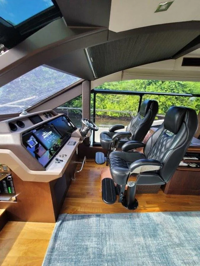 The helm features modern navigation equipment and comfortable seating with a panoramic view. aboard GODSPEED Yacht for Sale