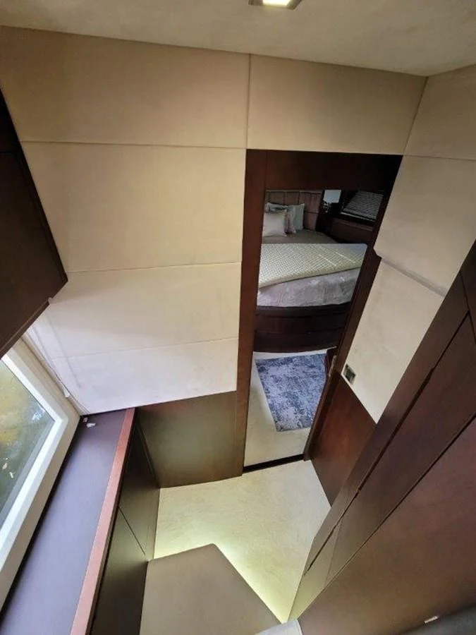 A modern yacht interior featuring a staircase leading to a cozy stateroom. aboard GODSPEED Yacht for Sale