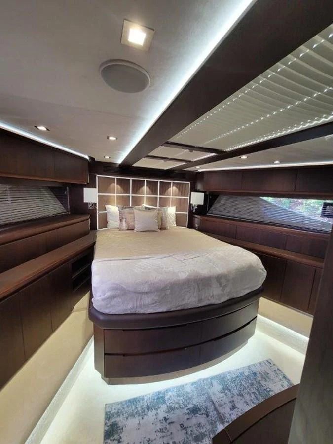 The stateroom features a luxurious bed with elegant wood finishes and ambient lighting. aboard GODSPEED Yacht for Sale