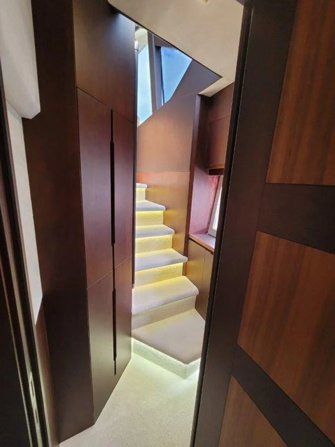 A sleek and modern staircase with ambient lighting leads to the upper deck. aboard GODSPEED Yacht for Sale