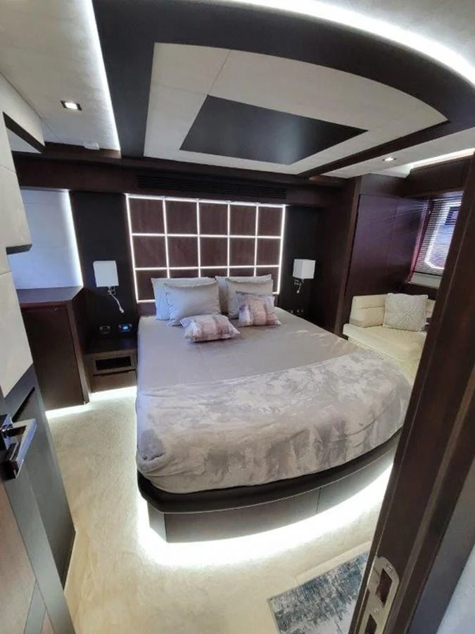 A luxurious stateroom featuring a large bed with elegant bedding and modern lighting. aboard GODSPEED Yacht for Sale