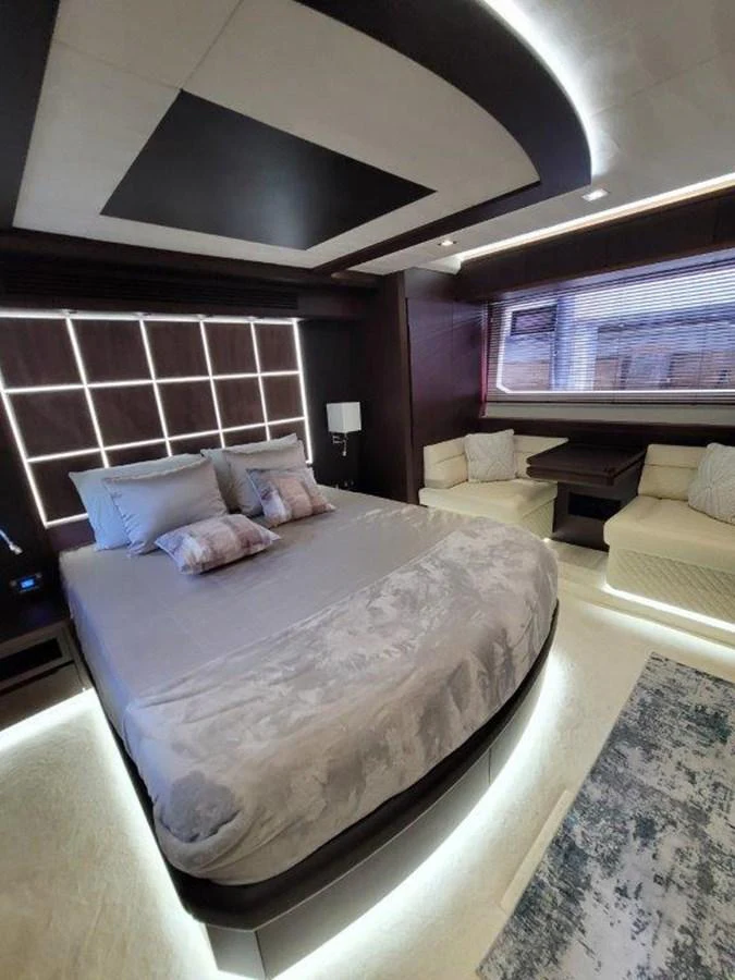 The master stateroom features a luxurious bed with elegant lighting and comfortable seating. aboard GODSPEED Yacht for Sale