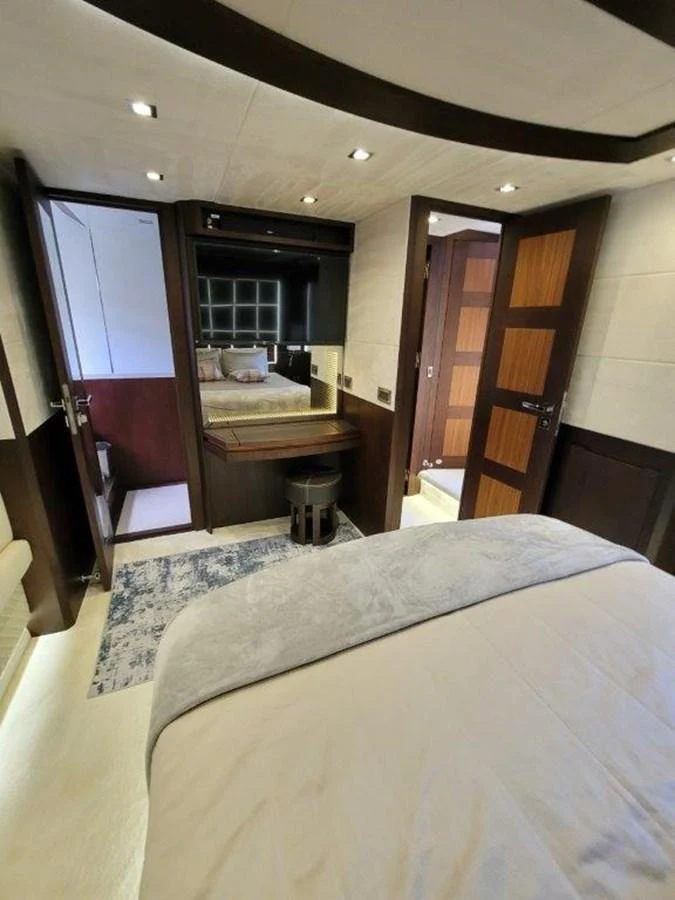 A cozy stateroom featuring a comfortable bed, a vanity, and an ensuite bathroom. aboard GODSPEED Yacht for Sale