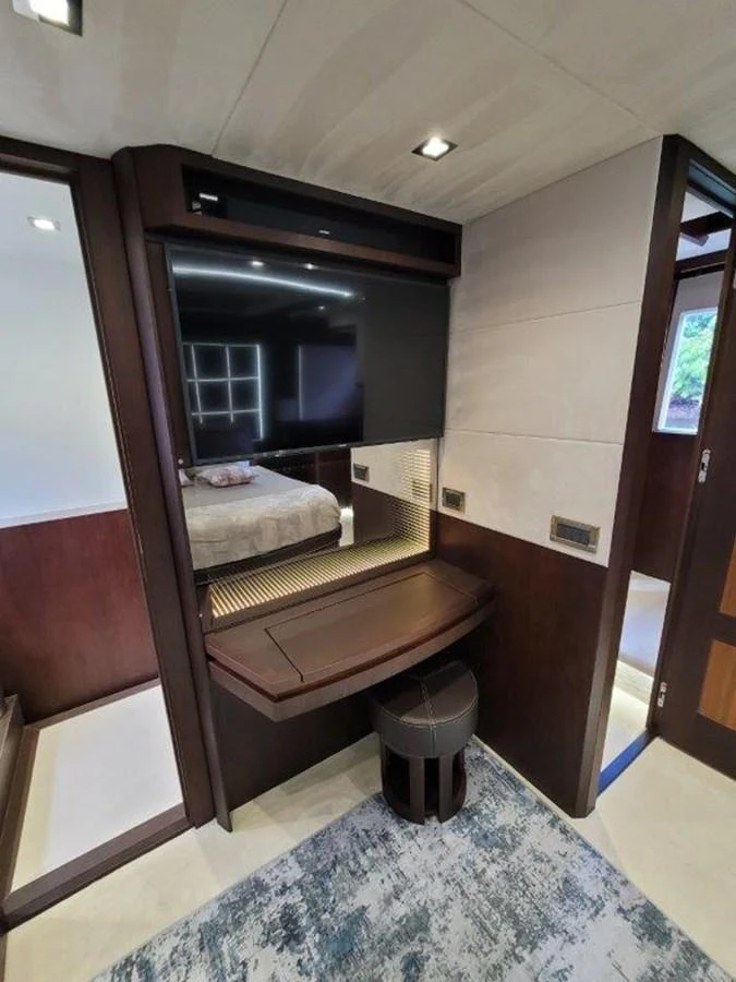 A luxurious stateroom featuring a sleek vanity and a plush bed in the background. aboard GODSPEED Yacht for Sale
