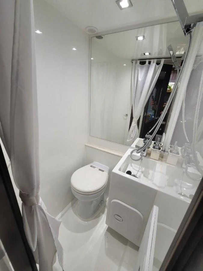 A sleek and modern yacht bathroom with white fixtures and ample lighting. aboard GODSPEED Yacht for Sale