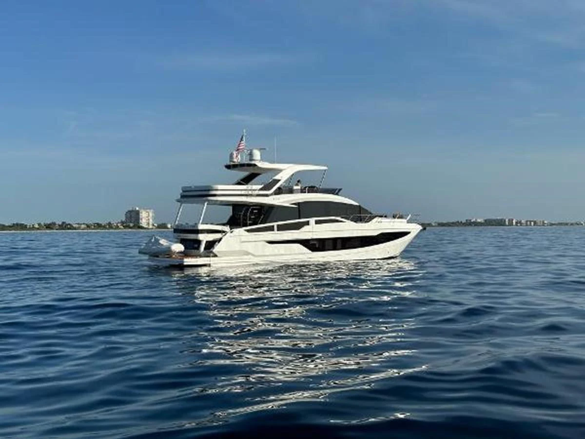 A sleek and modern yacht cruising on calm waters under a clear sky. aboard GODSPEED Yacht for Sale