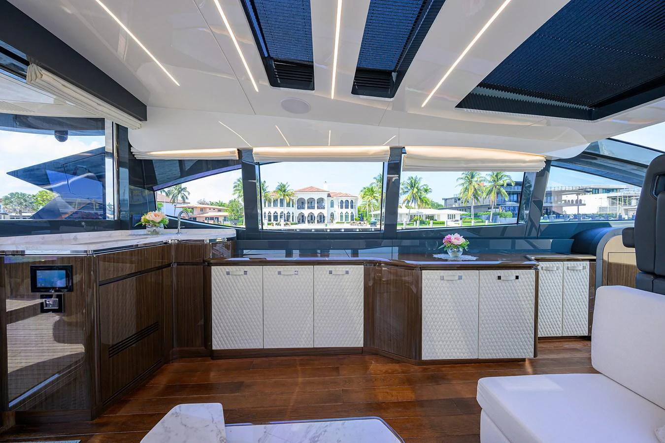 The salon features elegant wood flooring, ample natural light, and luxurious furnishings. aboard LAZZARA LSX 67 Yacht for Sale