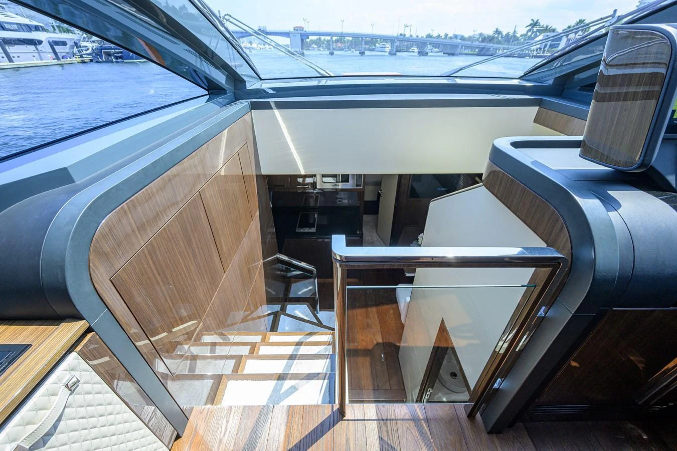 A stylish interior view showcasing the staircase leading to the lower deck, with modern wood finishes and ample natural light. aboard LAZZARA LSX 67 Yacht for Sale