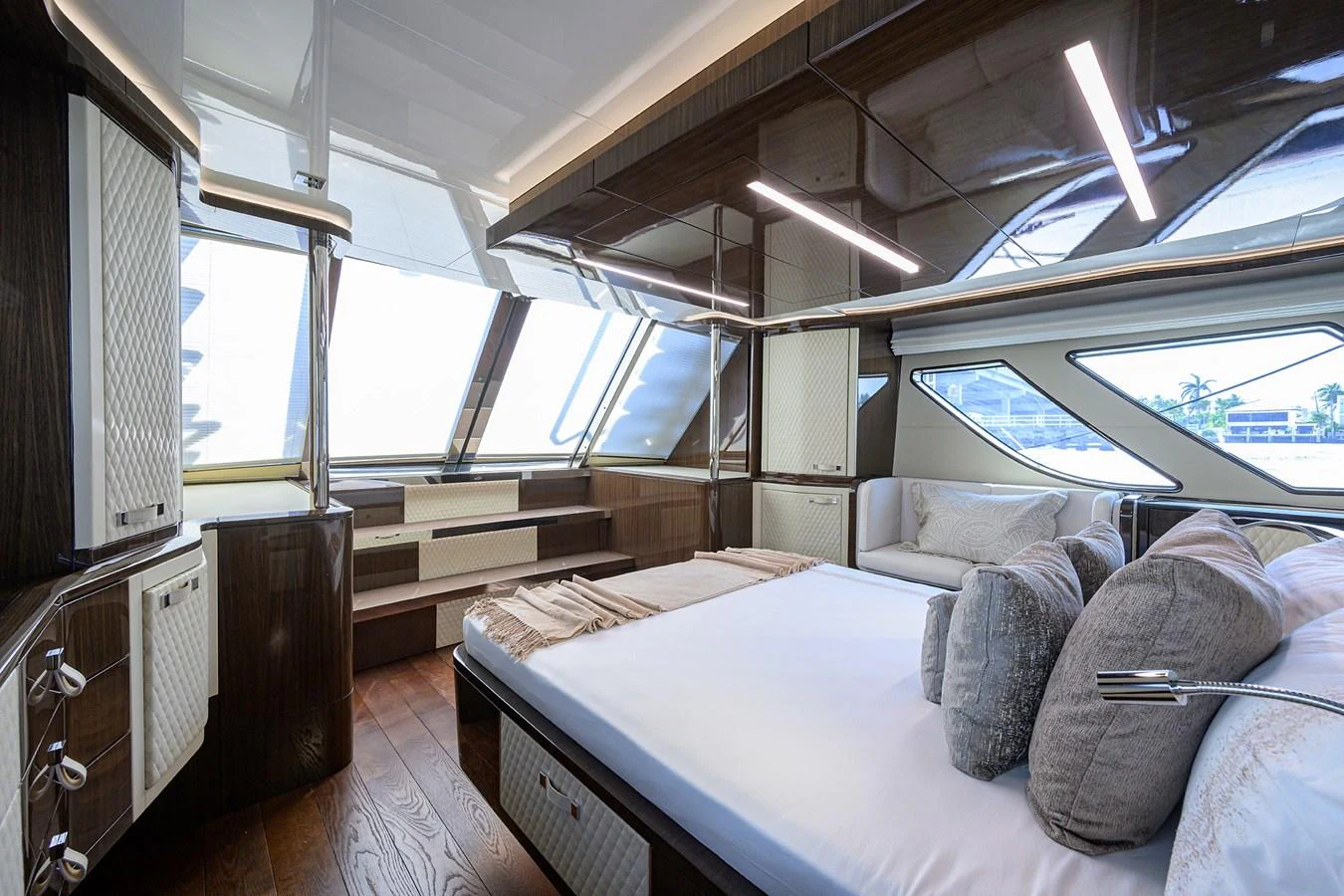 The master stateroom features a luxurious bed with ample natural light and elegant wood finishes. aboard LAZZARA LSX 67 Yacht for Sale