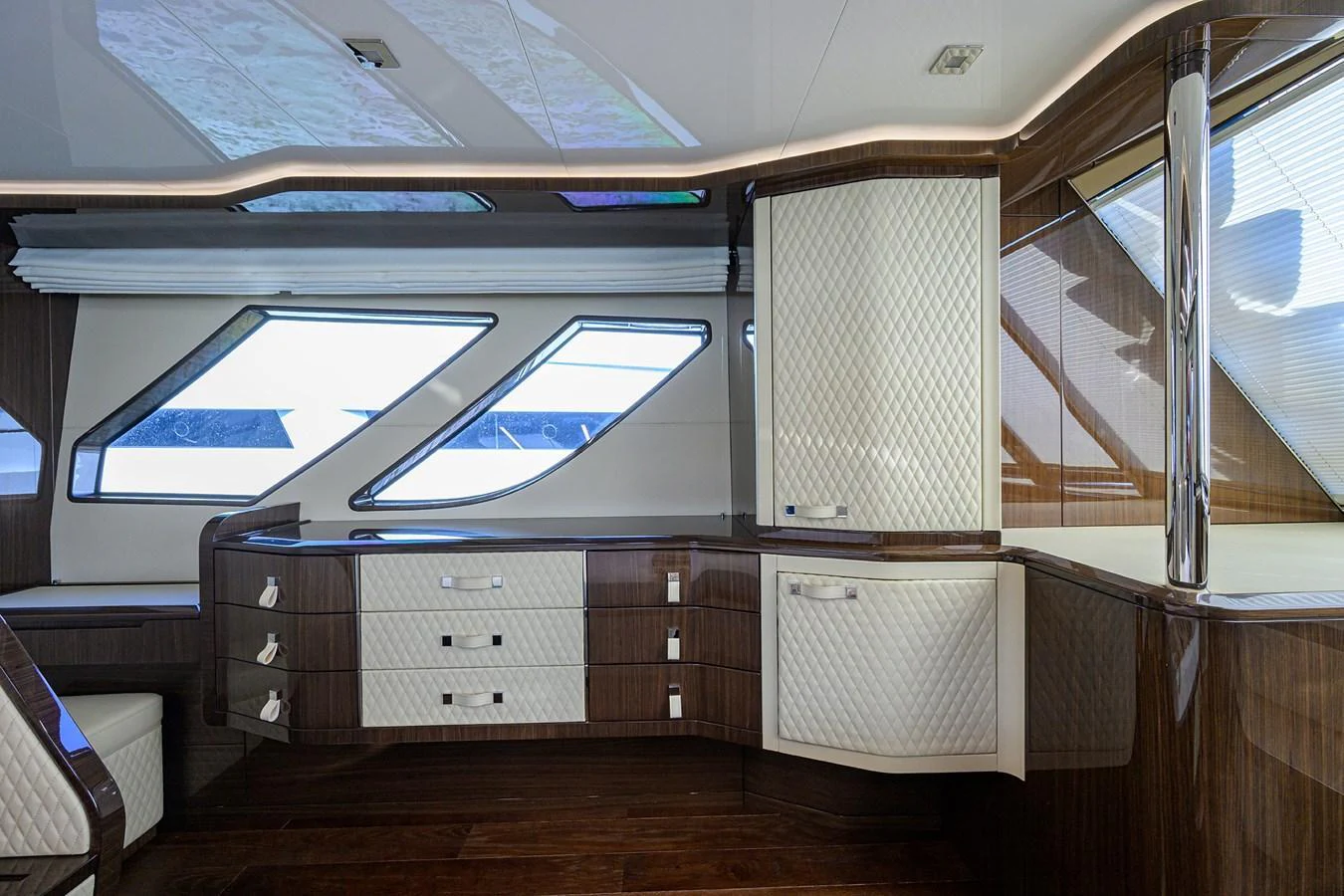 The yacht's interior features a sleek, modern design with polished wood and quilted white cabinetry. aboard LAZZARA LSX 67 Yacht for Sale