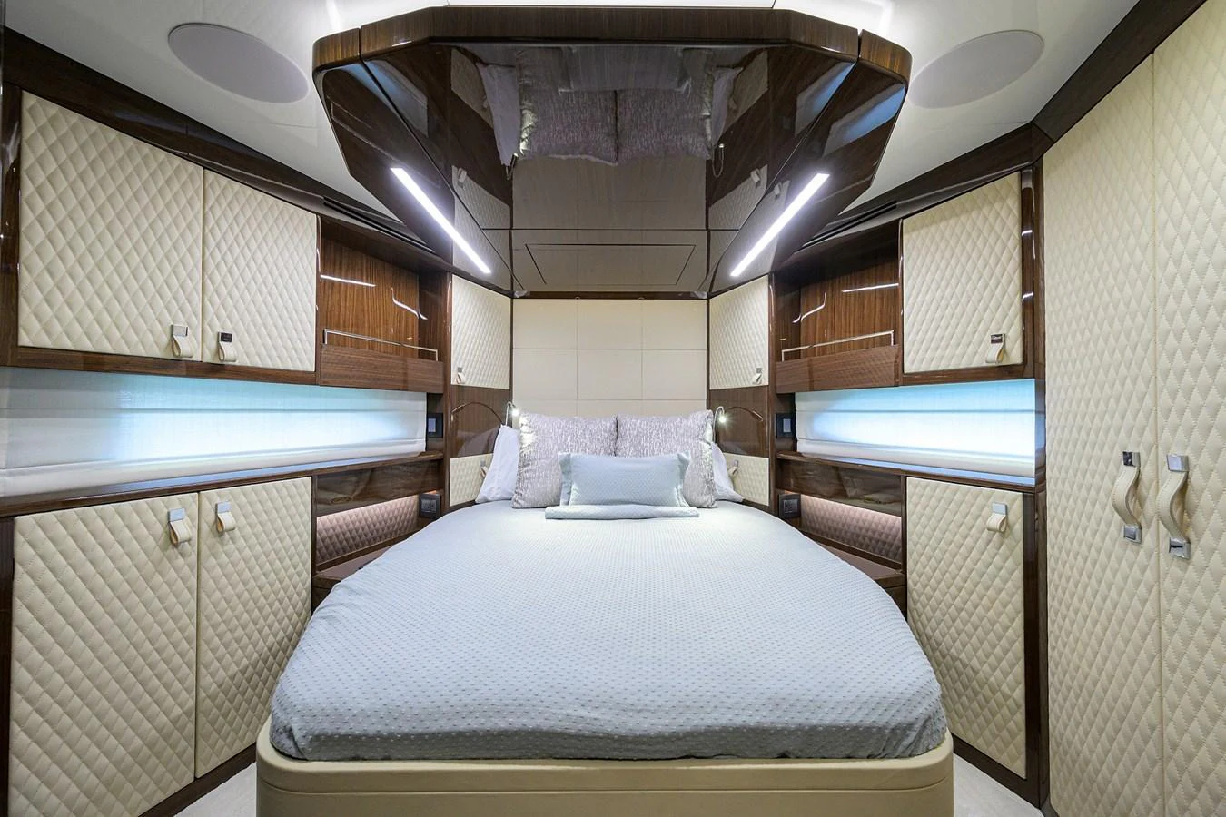 The stateroom features a luxurious bed with elegant wood and quilted paneling. aboard LAZZARA LSX 67 Yacht for Sale