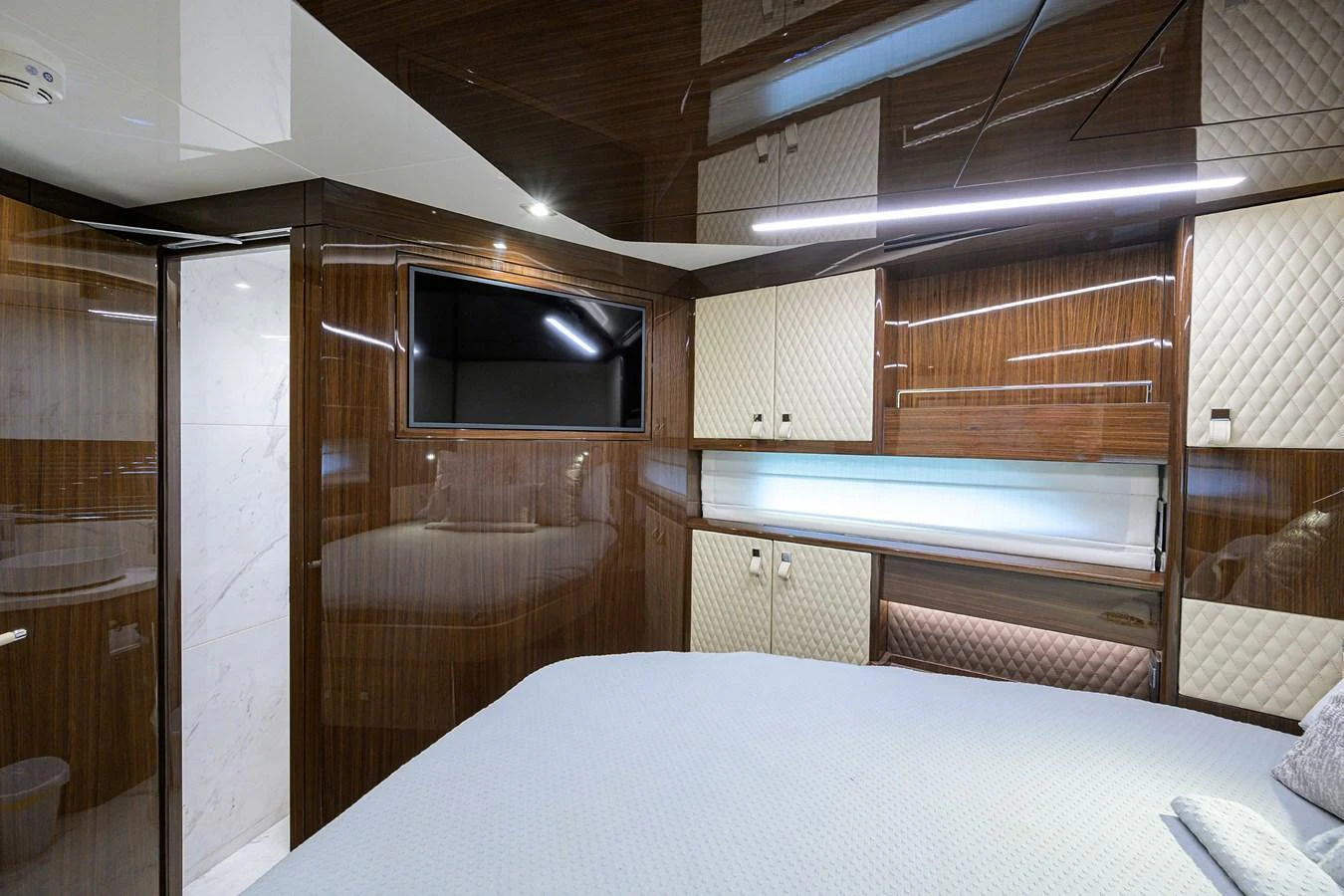 A luxurious stateroom featuring elegant wood paneling and modern amenities. aboard LAZZARA LSX 67 Yacht for Sale