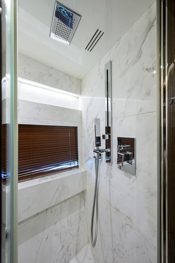 A luxurious marble shower area with modern fixtures. aboard LAZZARA LSX 67 Yacht for Sale