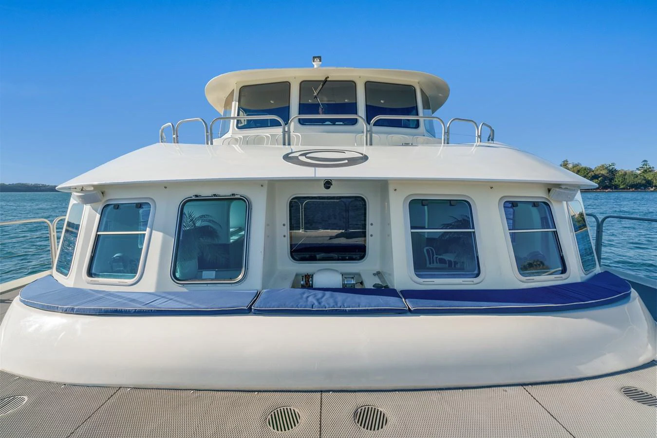 The yacht's exterior showcases a modern design with large windows and a spacious deck area. aboard COAST Yacht for Sale