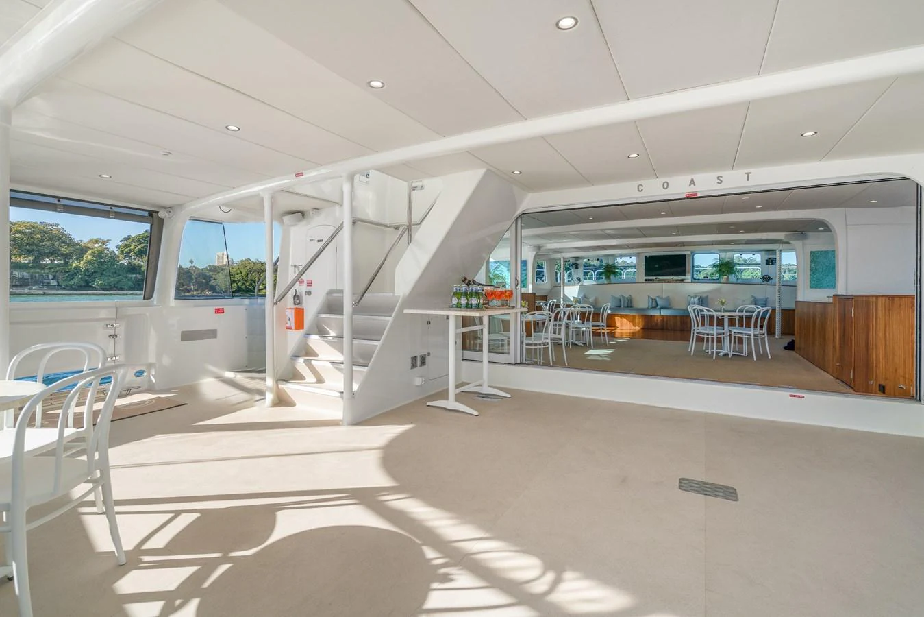 The spacious main salon features ample seating and large windows for natural light. aboard COAST Yacht for Sale