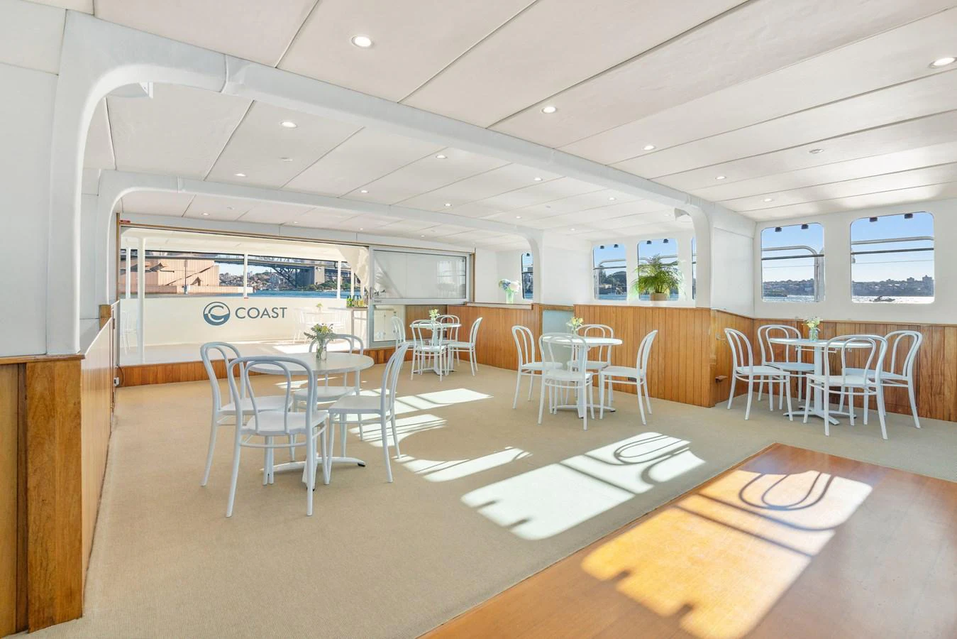 The yacht's interior dining area features elegant seating arrangements with ample natural light. aboard COAST Yacht for Sale