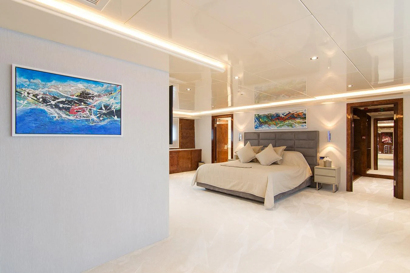 a bedroom with a bed and a painting on the wall aboard HALLO Yacht for Sale