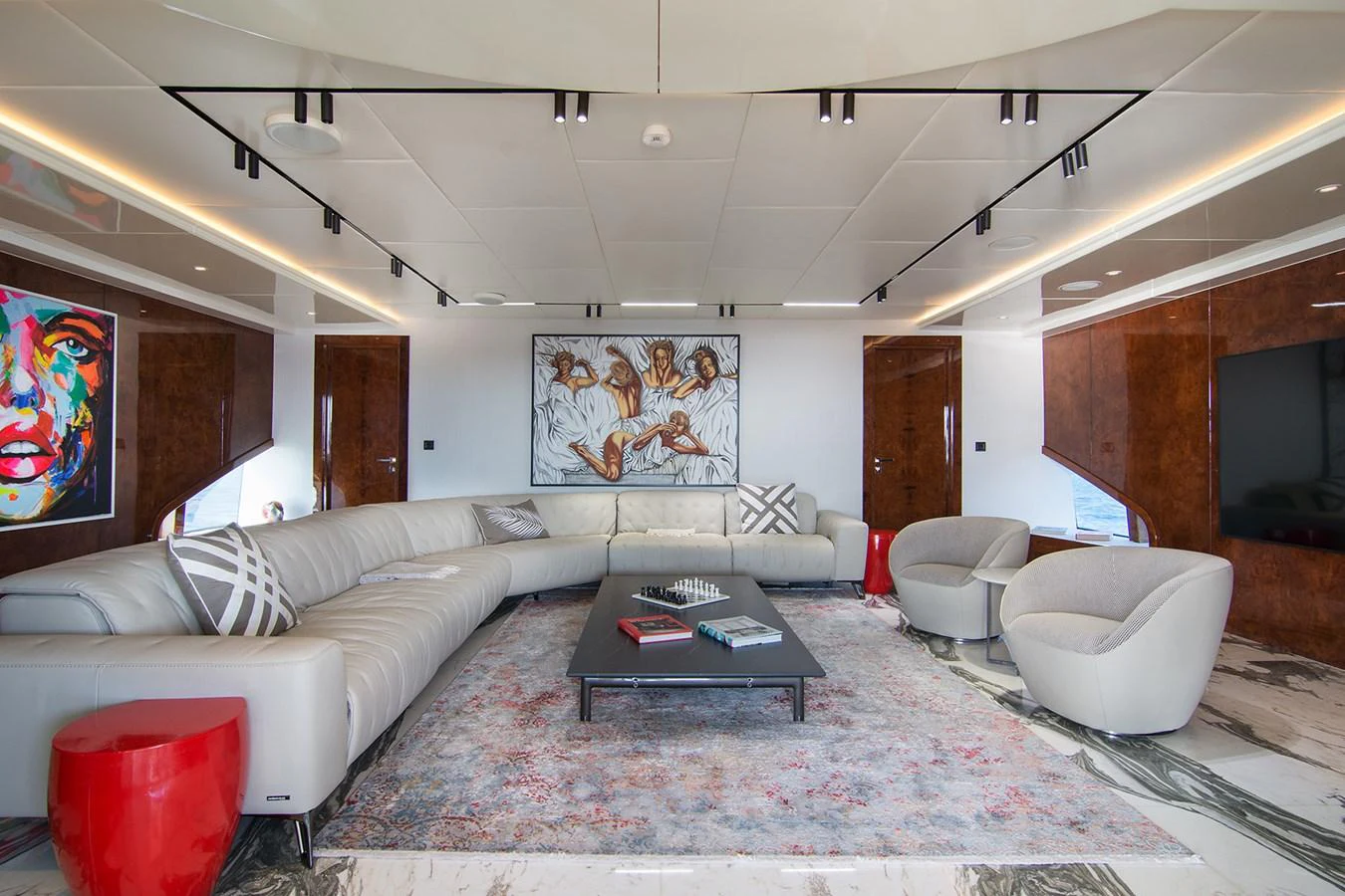 a living room with a large white couch and a large mirror aboard HALLO Yacht for Sale