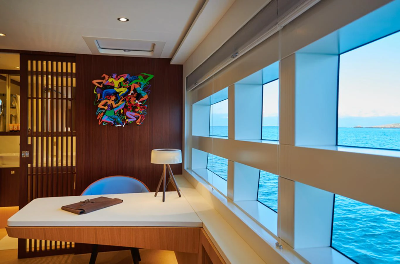A stylish office space with a modern desk and large windows offering a stunning ocean view. aboard LONG ISLAND 78 Yacht for Sale