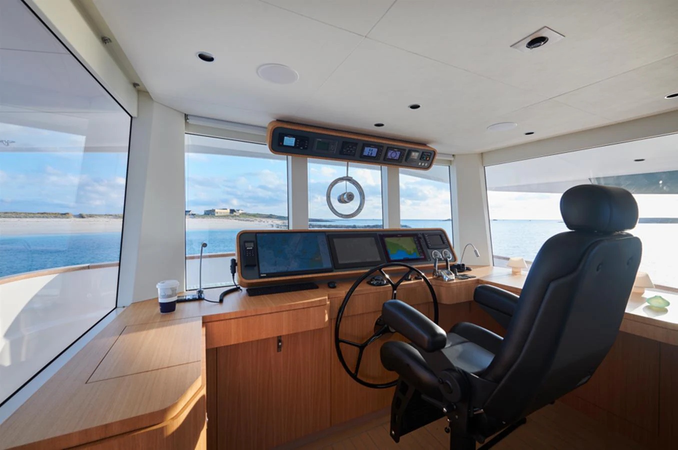 The helm station offers a panoramic view with state-of-the-art navigation equipment and a comfortable captain's chair. aboard LONG ISLAND 78 Yacht for Sale