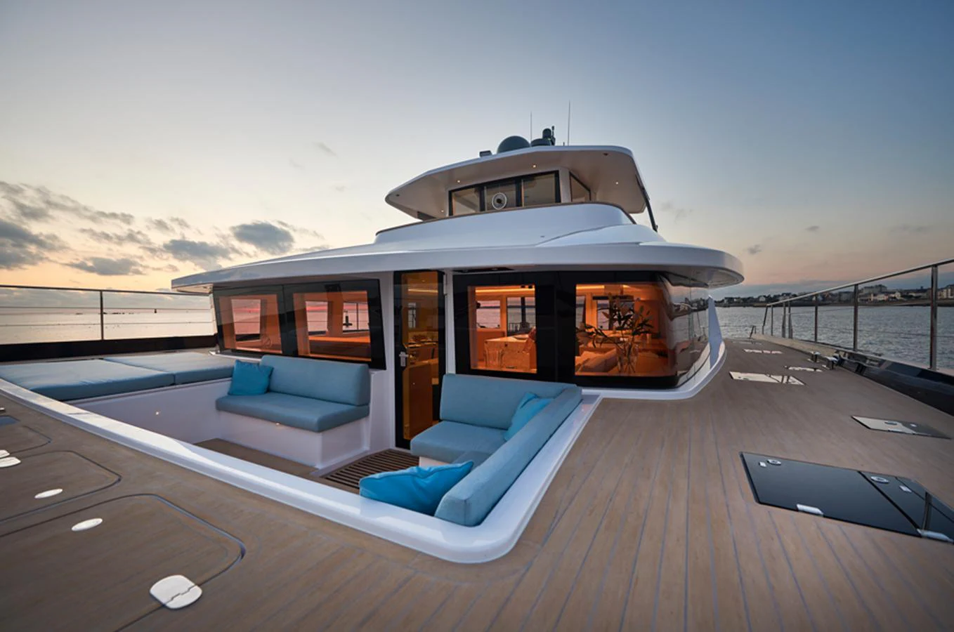 The yacht's aft deck features plush seating areas with a stunning view of the sunset over the water. aboard LONG ISLAND 78 Yacht for Sale