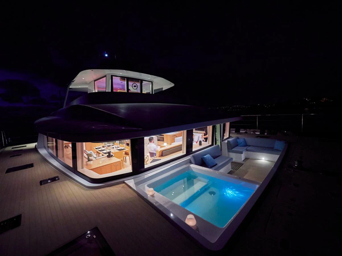 The yacht's aft deck features a luxurious pool and spacious seating area, beautifully illuminated at night. aboard LONG ISLAND 78 Yacht for Sale